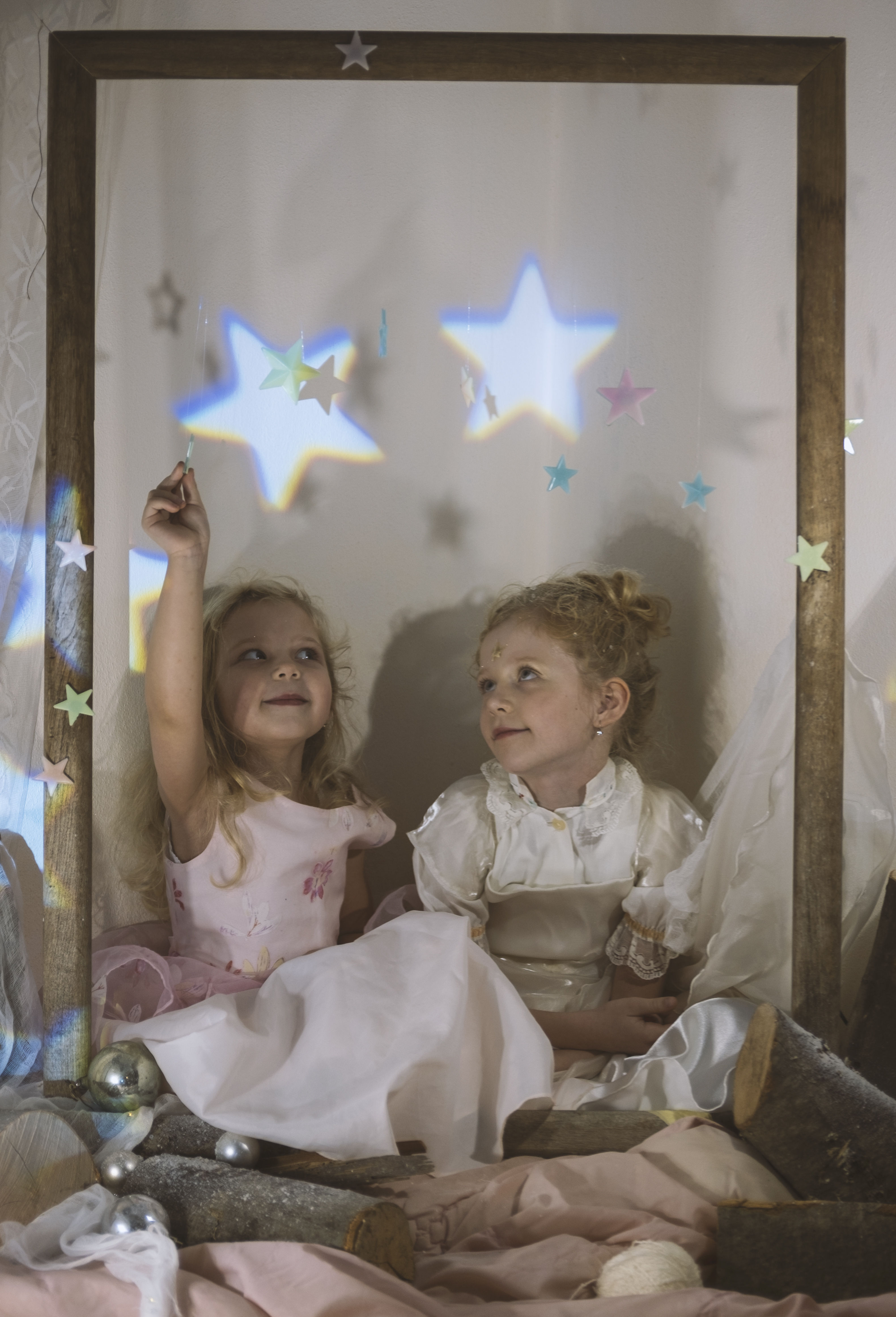 Frame in the air, and little blonde girls sat inside of it with magic stars and star projections on it.