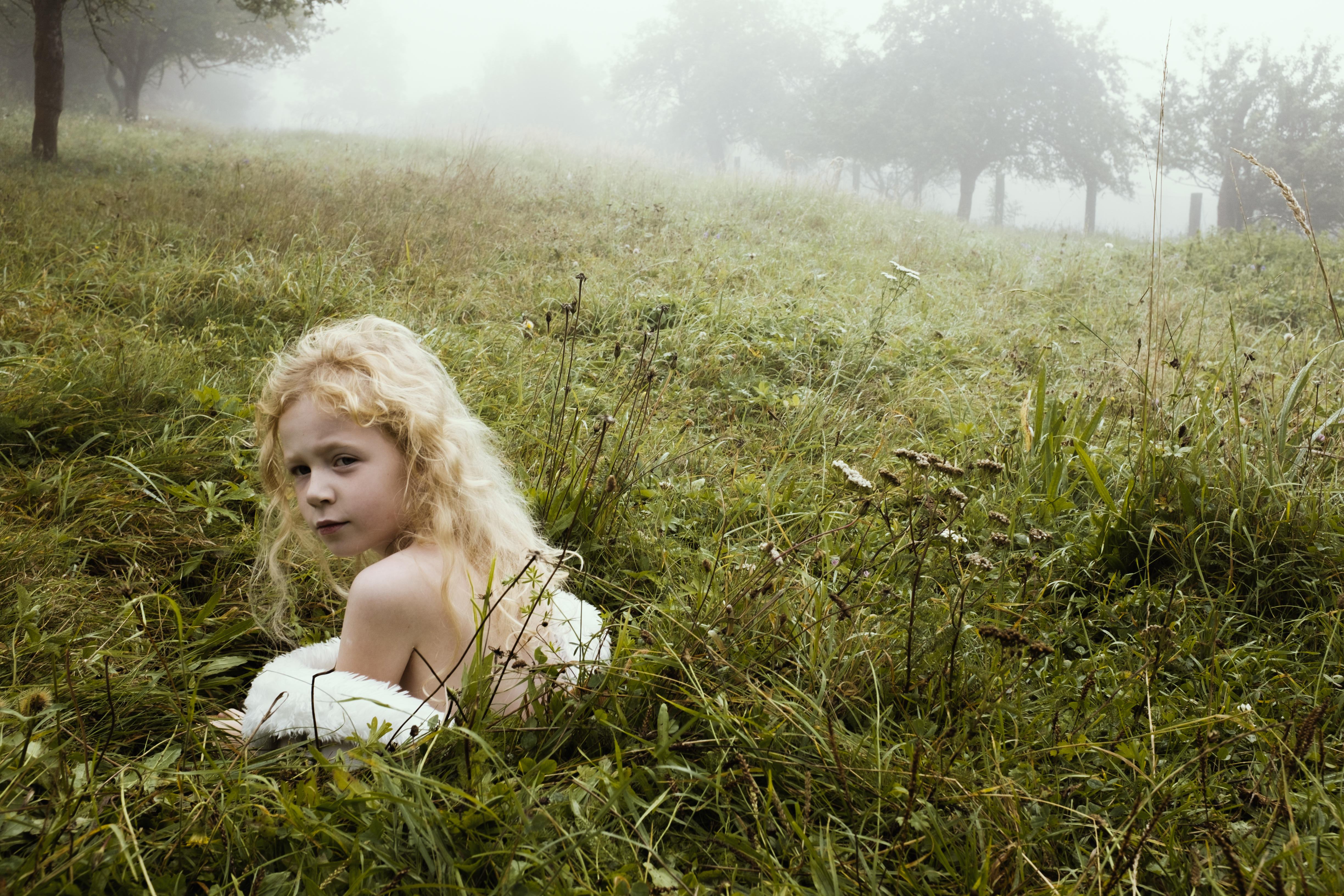 Little girl in a hole, summer time and on grass.