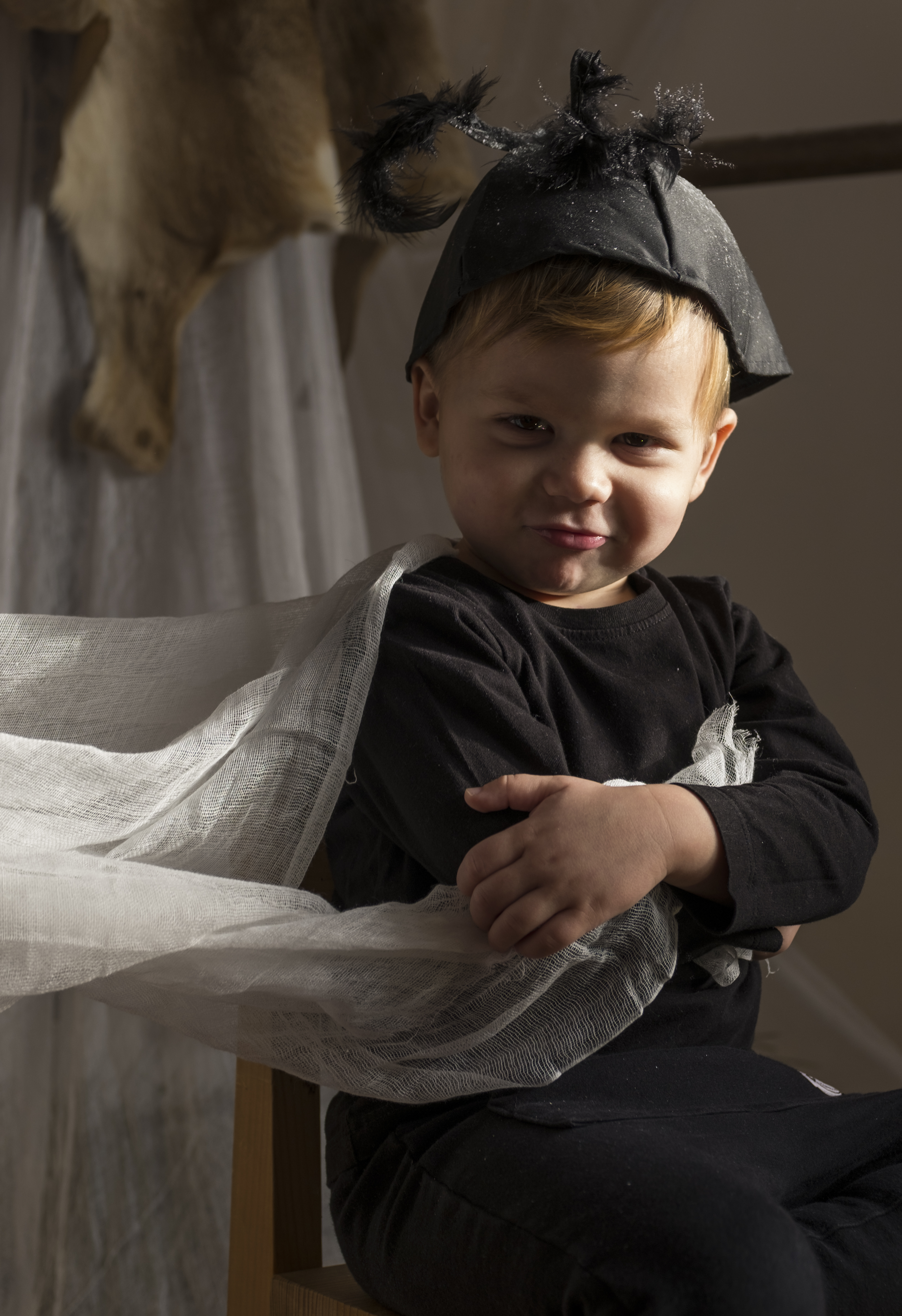 Little boy dressed as a black bug, looking puzzled.Natural lighting portraiture.