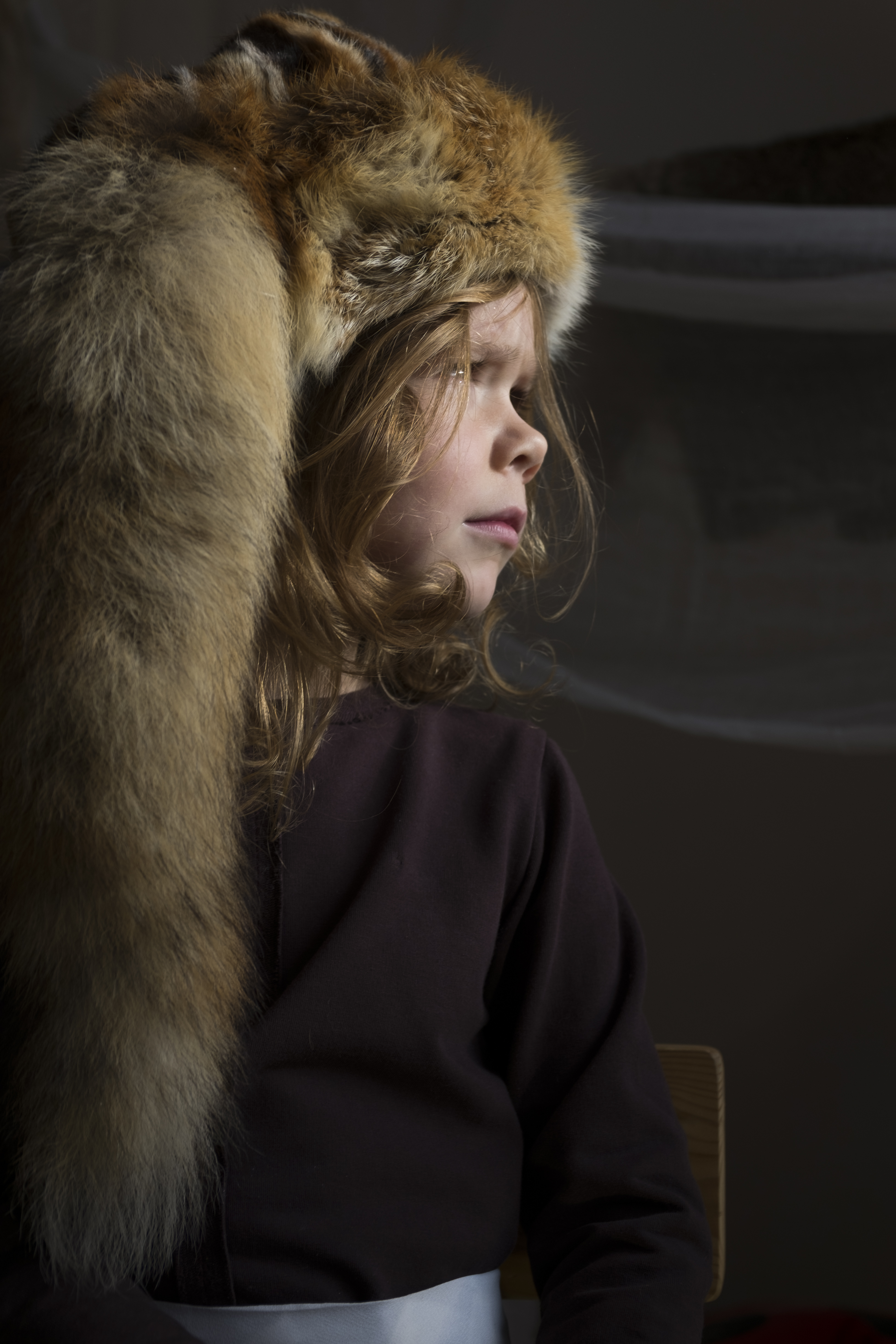 Girl with a fox hat, looking outside.